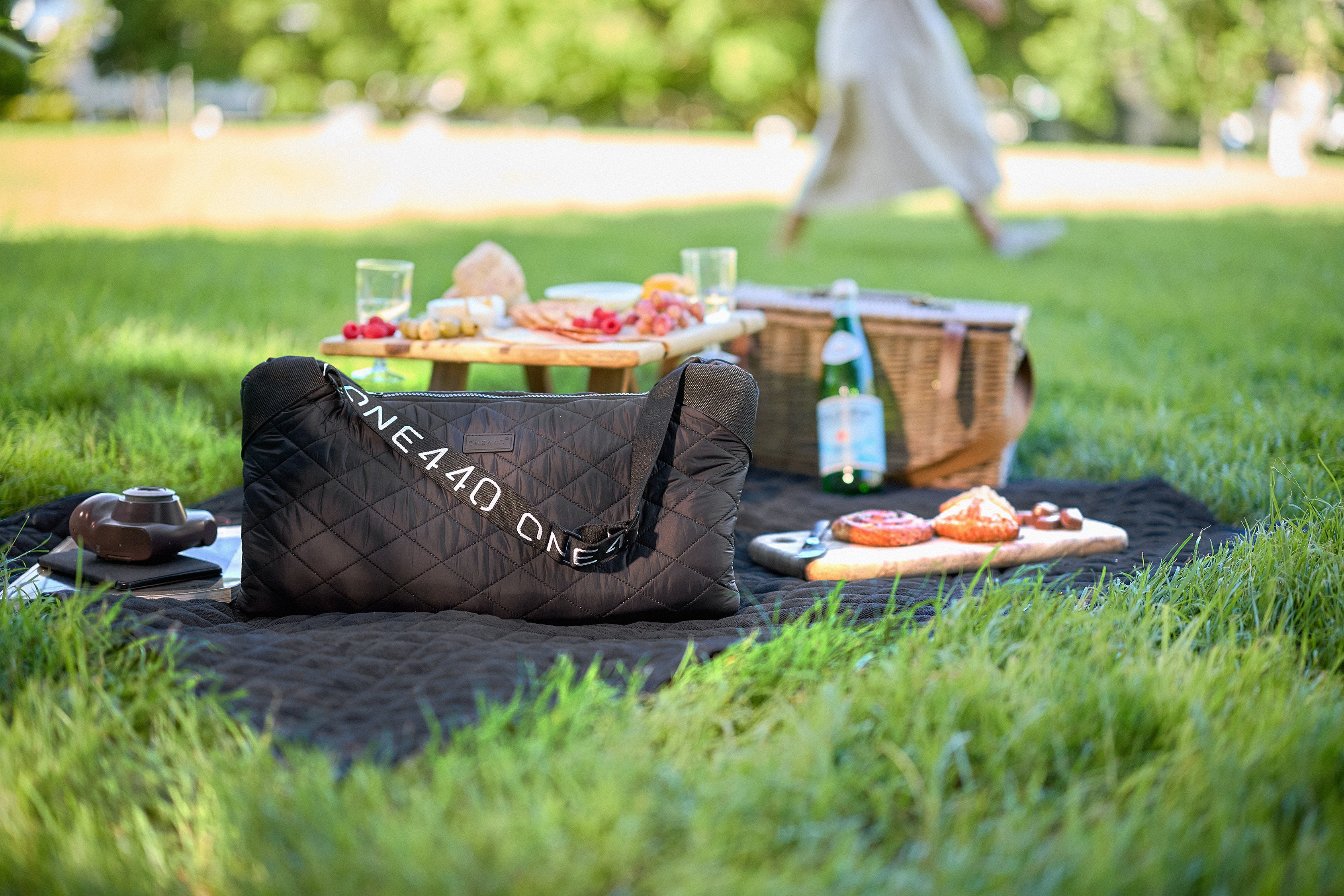 Picnic setup with a one440 bag on a blanket in a park