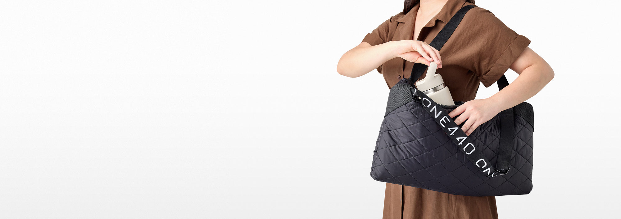 Person holding a black one440 tote bag with text on a white background